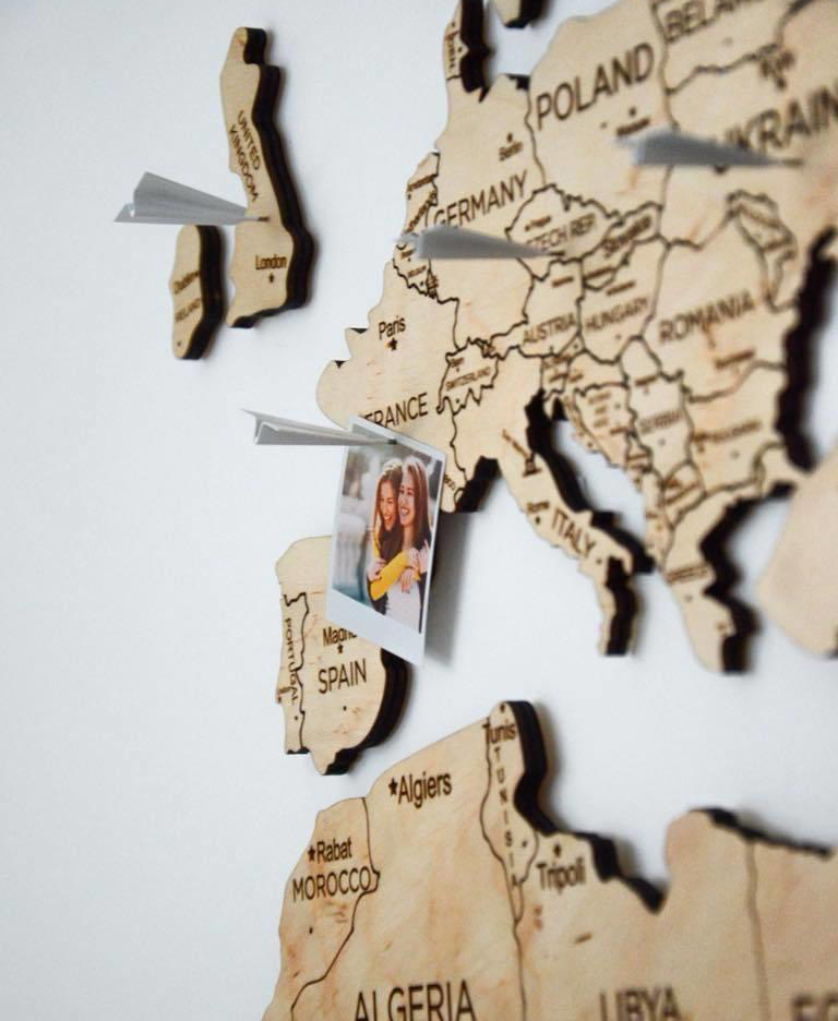 wooden map on the wall push pins airplanes